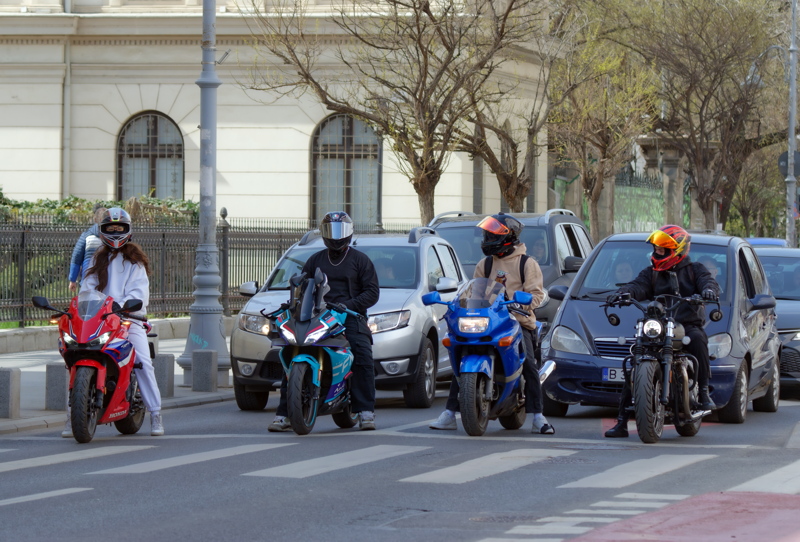 Motorcyclists and cars waiting for traffic lights